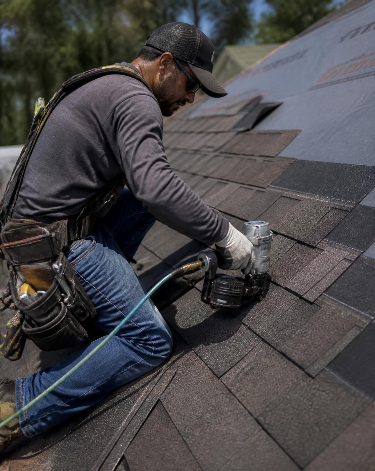 Roofing contractor installing asphalt shingles on a residential roof in Murfreesboro, Tennessee